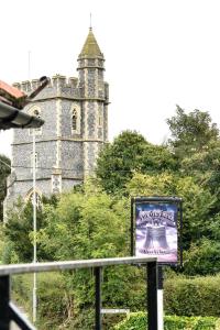 a sign in front of a building with a tower at The Old Bell in Wooburn