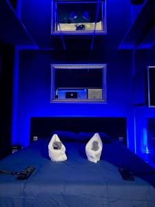 a blue bedroom with a bed with two white pillows at love room - Montbéliard in Montbéliard