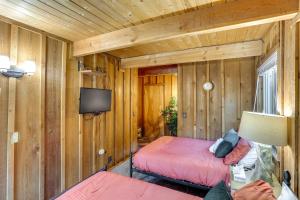Un dormitorio con dos camas y un televisor en una habitación. en Near Skiing and Hiking Dog-Friendly Big Bear Cabin, en Big Bear City