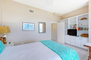 a white bedroom with a bed and a television at Plein Air Point in Marathon +18 photos