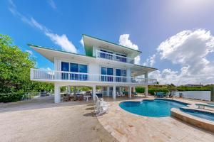 a large house with a swimming pool in front of it at Plein Air Point in Marathon