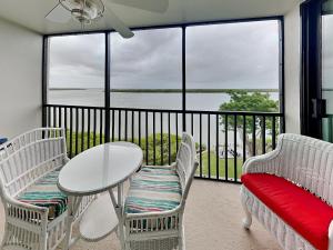 フォートマイヤーズビーチにあるPalms of Bay Beach 4Dの水辺の景色を望むバルコニー(テーブル、椅子付)