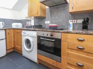 a kitchen with a stove and a washing machine at Ty Siabod in Betws-y-coed