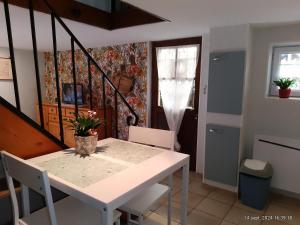 ein Esszimmer mit einem weißen Tisch und Stühlen in der Unterkunft charmante maisonnette au calme in Montélimar