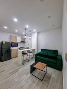 伊瓦格Hotel STATION 23的带绿色沙发的客厅和厨房