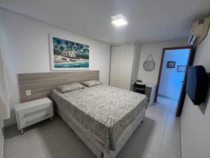a bedroom with a bed and a painting on the wall at Apto 304-D, 1 quarto completo! in Tamandaré +48 photos
