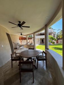 a patio with a table and chairs and a ceiling fan at Villas Cononda in La Majahua