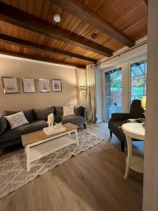 ein Wohnzimmer mit Sofa und Tisch in der Unterkunft Cottage & Garden & Sauna am See in Wettringen