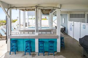 eine Bar mit blauen Hockern und einem Pool in der Unterkunft Blue Diamond by Pier 42 Vacations Oceanfront Luxury for 30 Guests in Holden Beach