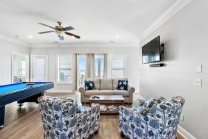 ein Wohnzimmer mit einem Billardtisch und zwei Stühlen in der Unterkunft Blue Diamond by Pier 42 Vacations Oceanfront Luxury for 30 Guests in Holden Beach