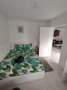 a bedroom with a bed with a green comforter at Appartement T4 in Sevran +4 photos