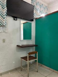 a chair sitting in a room with a green wall at Hotel Libramiento Puerto Vallarta in Puerto Vallarta +5 photos