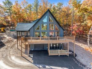 a house with a large deck in the woods at Epic Mtn Views I Luxe 5br Alpine Escape in McGaheysville