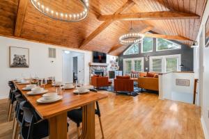 comedor y sala de estar con una gran mesa de madera en 6br Luxe Cabin Sleeps 16 Hot Tub & Pool Table, en McGaheysville