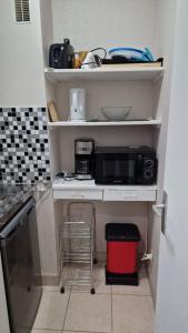 Una pequeña cocina con encimera y microondas. en Getaway for two cosy apartment with balcony, en Trouville-sur-Mer