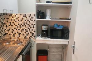 cocina pequeña con microondas y cafetera en Getaway for two cosy apartment with balcony, en Trouville-sur-Mer