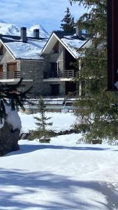 a house with snow on the ground in front of it at Chalet pareado para familias in Formigal