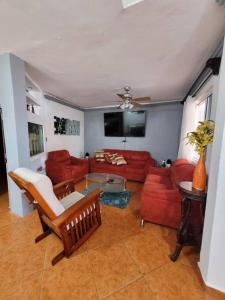 a living room with red couches and a tv at casa en veracruz in Veracruz