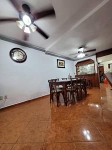 a dining room with a table and chairs and a clock at casa en veracruz in Veracruz