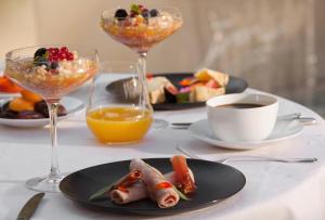a table topped with two plates of food and drinks at Hôtel Mas de Boudan**** in Nîmes +4 photos