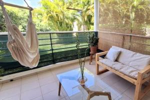 a porch with a hammock and a swing at Coeur de Rhoda in Saint-François