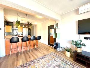 a living room with bar stools and a kitchen at Central loft apartments in Santa Pola