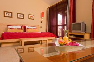 een woonkamer met een bed en een tafel met een fruitschaal bij Ocean Beauty in Pereybere