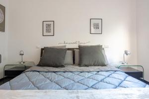 a white bedroom with a large bed with two lamps at Fleming hill apartments - Free Private Parking & Garden in Rome