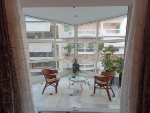 a room with a table and chairs and windows at La Dolce Vita in Chalkida