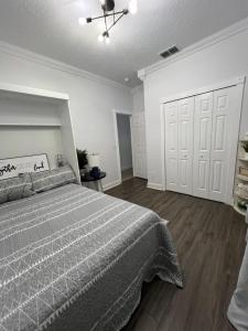 1 dormitorio con cama, paredes blancas y suelo de madera en Staycation Spot, en Orlando 16 fotos más