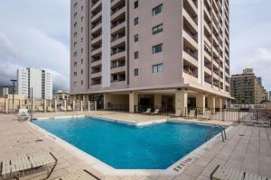 a swimming pool in front of a building at HEART of WAIKIKI,1BDRM,FREE PARKING, WIFI,NO RESORT FEES,YOUTUBE,NETFLIX ! in Honolulu