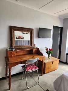 a desk with a mirror and a chair in a room at Scenic Blue Studio in Simonʼs Town