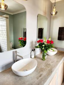 a bathroom with two sinks and a large mirror at Scenic Blue Studio in Simonʼs Town