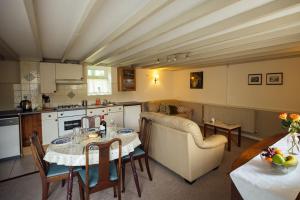 a living room with a table and a kitchen at Birch Cottage - Tranquil Country Cottage with Indoor Swimming Pool in Haverfordwest
