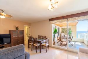a dining room and living room with a table and chairs at Playa Muchavista Terraza Vista Mar in La Venteta