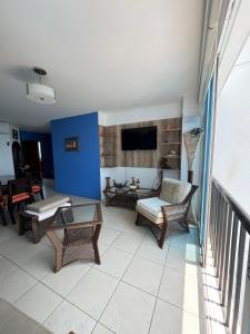a living room with wicker chairs and a tv at Departamento Punta Centinela frente al mar in Santa Elena