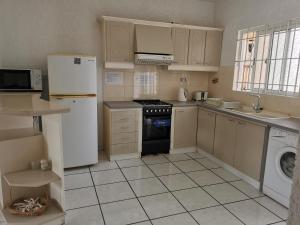 a kitchen with a refrigerator and a stove and a dishwasher at Le Dattier in Flic-en-Flac