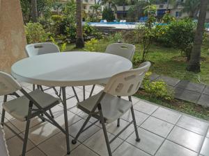 a white table and chairs on a patio at Le Dattier in Flic-en-Flac
