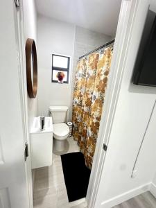 Un baño con inodoro y cortina de ducha. en Artful Luxury in Miami Most Iconic Spot, en Miami