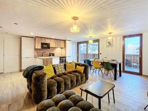 a living room with a couch and a table at Appartement rénové, ski aux pieds, centre station, 8 pers, balcon, WiFi - FR-1-267-301 in La Toussuire