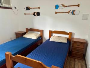 two twin beds in a room with two woodenunks at Casa Becker - Praia Seca in Araruama