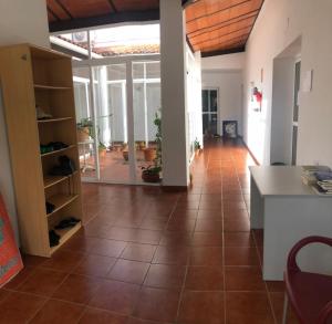 a living room with a tile floor and a kitchen at Albergue Peregrinos El Carrascalejo in El Carrascalejo