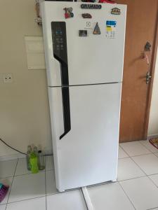 Una nevera blanca en una cocina con imanes. en Apartamento, en Manaus