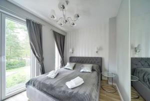 a bedroom with a bed with two towels on it at Apartament Glamour in Pobierowo