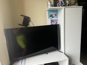 TV de pantalla plana grande en un soporte blanco en Apartamento, en Manaus