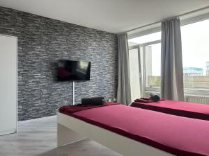 a bedroom with two beds and a tv on a brick wall at Monteur-Apartment ,CityHome in Marl