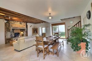 een woonkamer met een tafel, een bank en een open haard bij De dartagnan in Val Couesnon