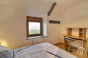 een slaapkamer met een bed, een bureau en een raam bij De dartagnan in Val Couesnon
