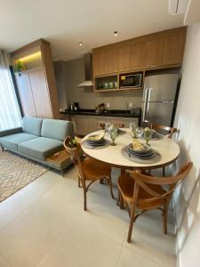 a kitchen and living room with a table and a couch at Apartamento Sunset Residence in Dourados
