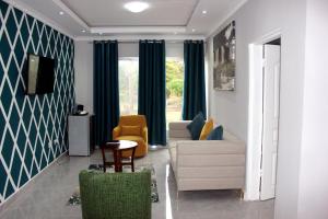 a living room with a couch and chairs and a table at Fatmols Hotels in Lusaka